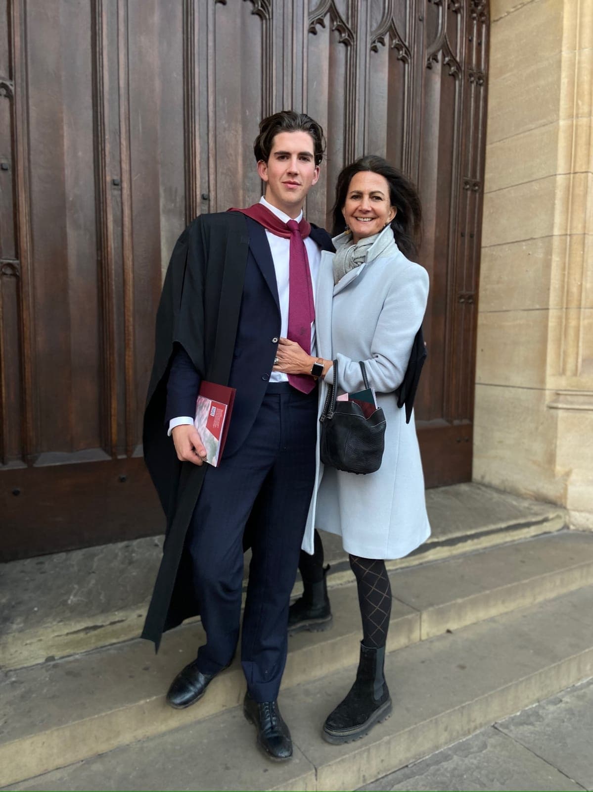 Louis in graduation gown with family outside the Wills Memorial Building