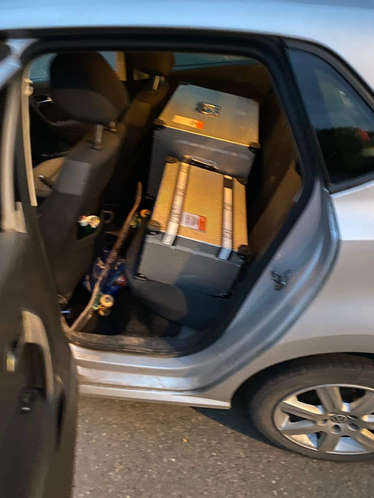 Camera flight cases loaded into the back seat of a small car