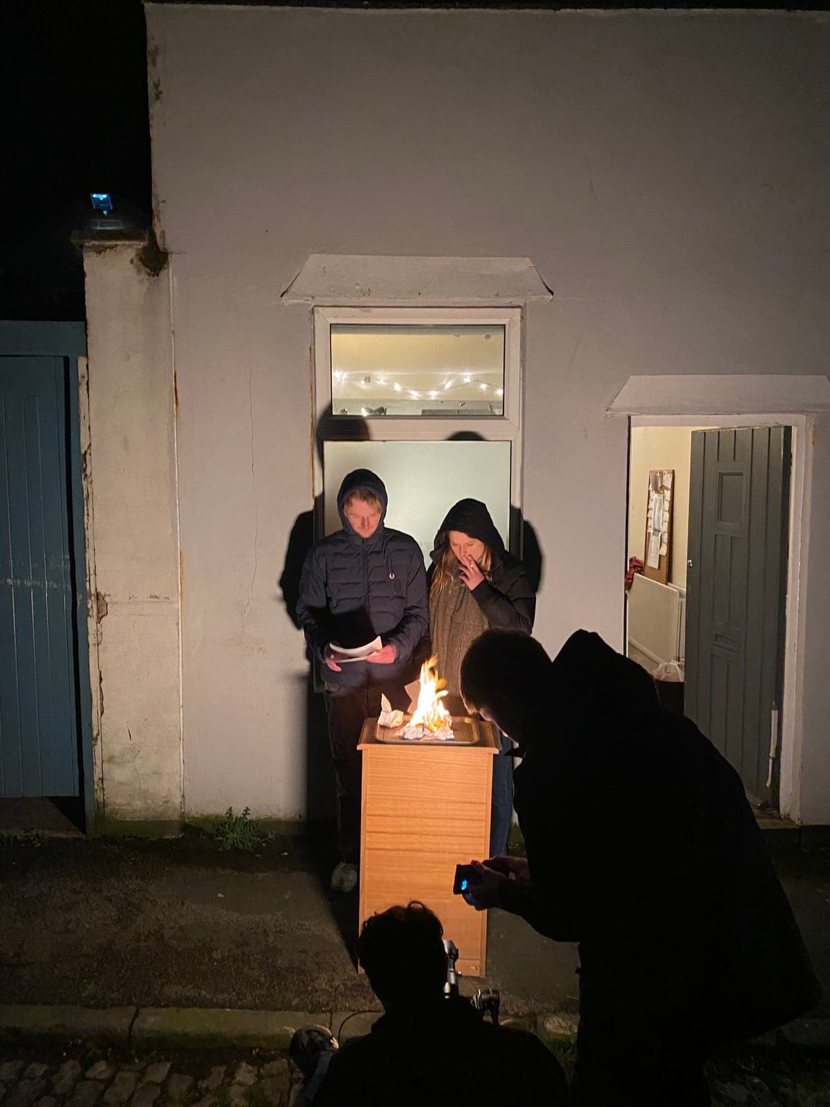 A night scene being filmed around a fire